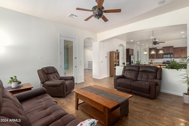 living room featuring wood-type flooring and ceiling fan