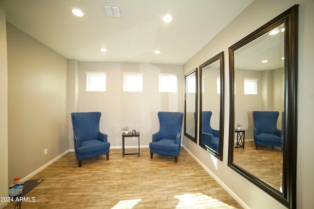 living area with a wealth of natural light and light hardwood / wood-style flooring