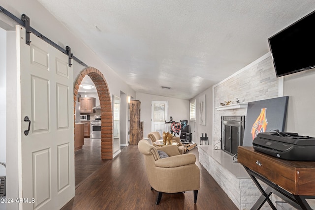 living room featuring lofted ceiling, dark hardwood / wood-style floors, a textured ceiling, and a fireplace