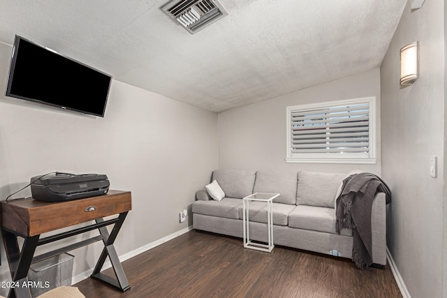 living room featuring a textured ceiling, lofted ceiling, and dark hardwood / wood-style floors