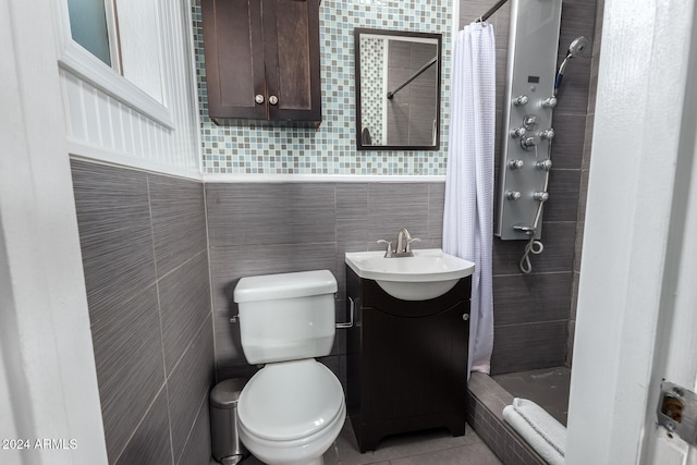 bathroom featuring vanity, toilet, tile walls, and curtained shower