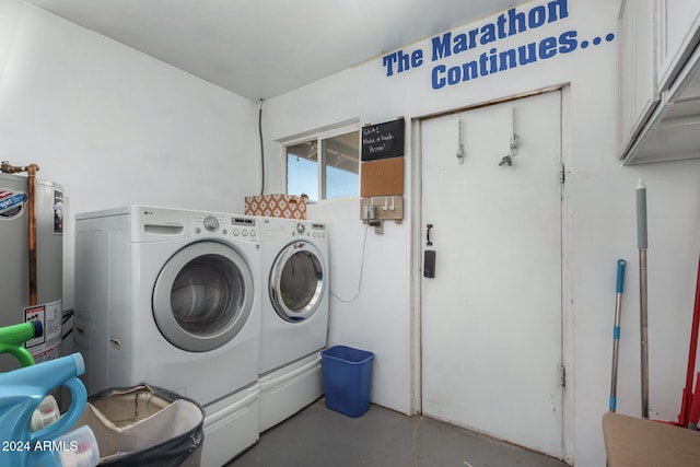 laundry room with water heater, washing machine and clothes dryer, and cabinets