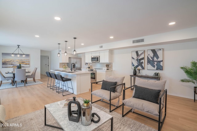 living room with light hardwood / wood-style floors and sink