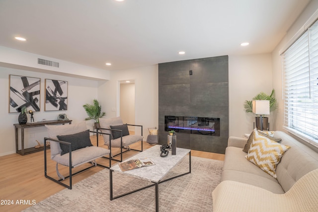 living room with a fireplace and light wood-type flooring