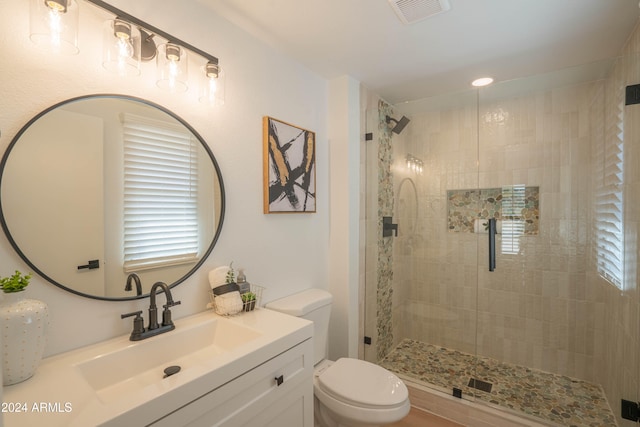 bathroom with toilet, vanity, and an enclosed shower