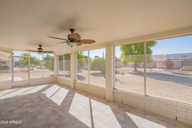 unfurnished sunroom featuring ceiling fan