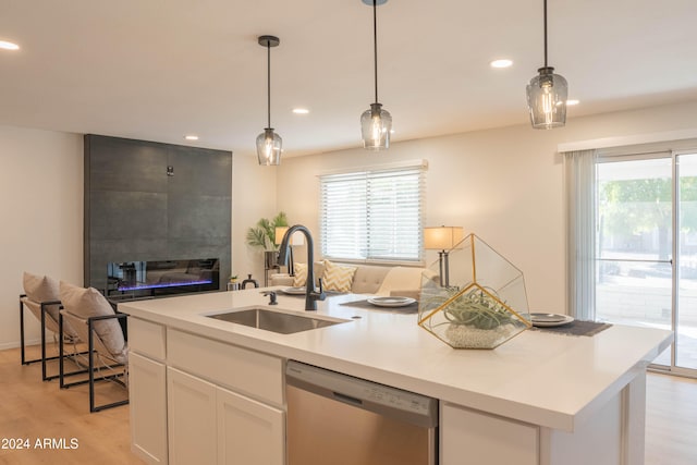 kitchen featuring a center island with sink, white cabinets, a wealth of natural light, sink, and stainless steel dishwasher