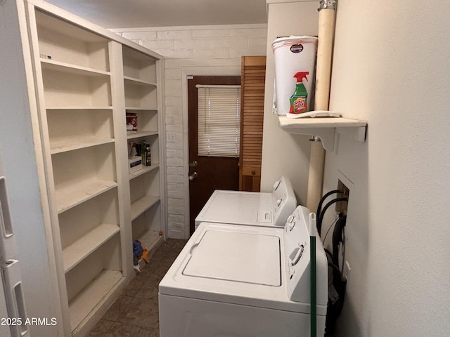 washroom featuring dark tile patterned floors, washing machine and dryer, and laundry area