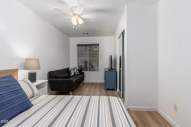 bedroom with ceiling fan, hardwood / wood-style floors, and a closet