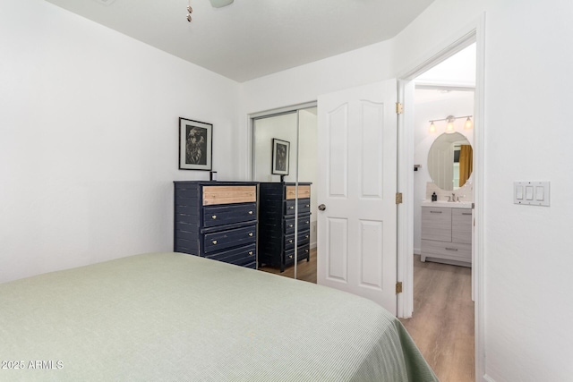 bedroom featuring sink, light hardwood / wood-style flooring, and a closet