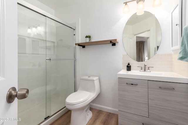 bathroom featuring toilet, an enclosed shower, tasteful backsplash, vanity, and hardwood / wood-style floors