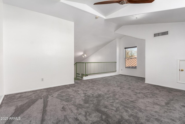 interior space with vaulted ceiling, ceiling fan, and dark colored carpet