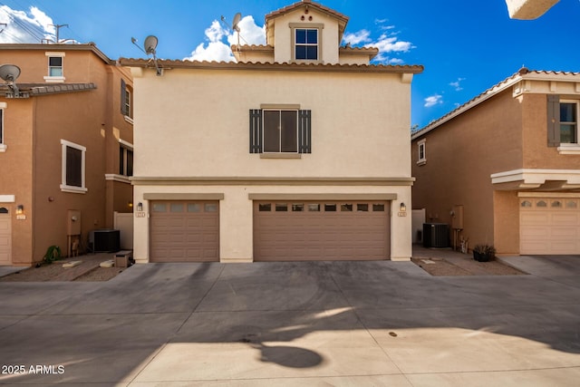 mediterranean / spanish-style home featuring central AC and a garage