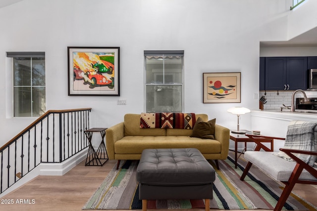 living room featuring sink and light hardwood / wood-style floors