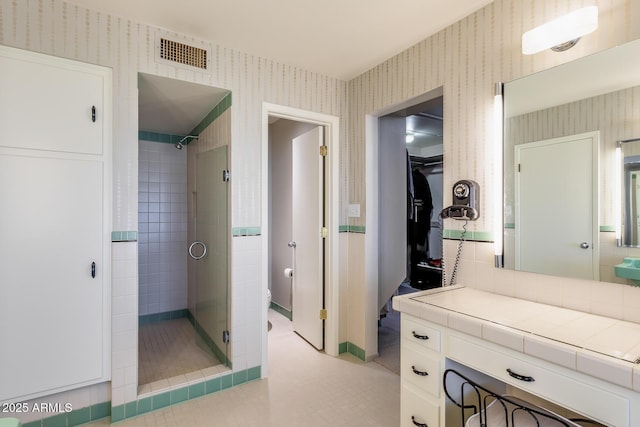 bathroom with toilet, a shower with shower door, and vanity