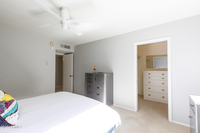 bedroom featuring a closet, ceiling fan, light colored carpet, and a spacious closet