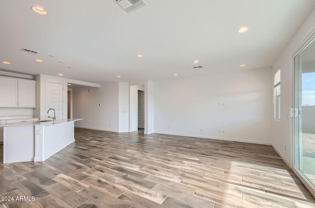 unfurnished living room featuring light hardwood / wood-style floors and sink