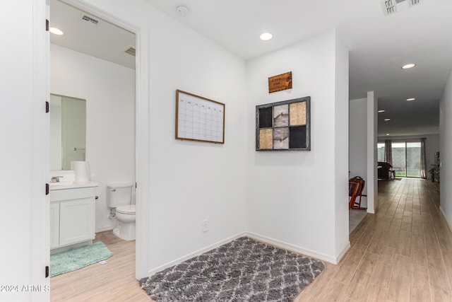 hallway with sink and light hardwood / wood-style flooring