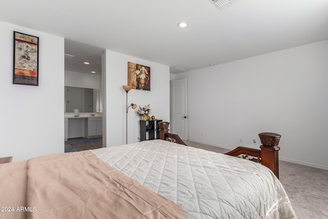 bedroom with connected bathroom and carpet floors