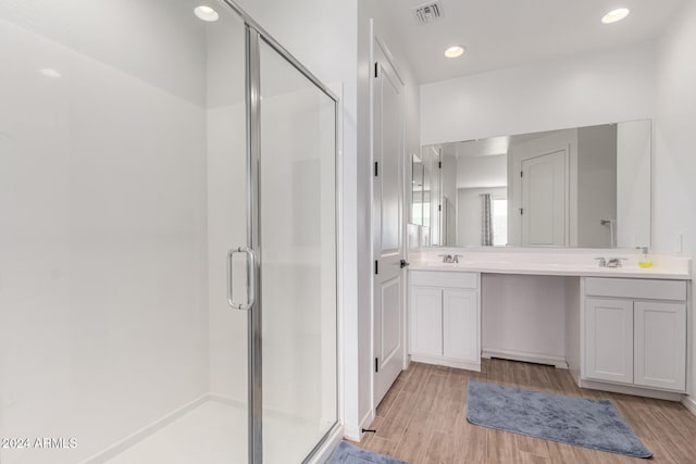 bathroom with vanity, wood-type flooring, and a shower with door