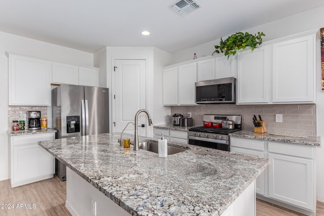 kitchen featuring appliances with stainless steel finishes, light hardwood / wood-style floors, white cabinetry, and sink