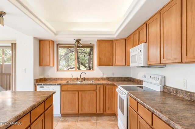 kitchen with white appliances, plenty of natural light, a raised ceiling, and a sink