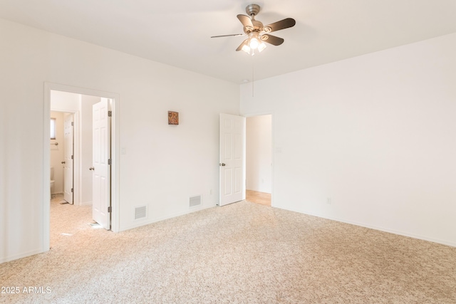 spare room featuring ceiling fan, visible vents, and light colored carpet