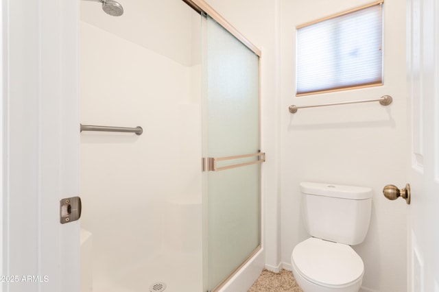 full bathroom with baseboards, a shower stall, and toilet