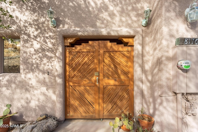 details featuring electric meter and stucco siding