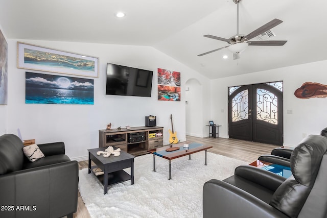 living room featuring lofted ceiling, french doors, ceiling fan, and light wood-type flooring