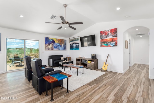 living room with ceiling fan, vaulted ceiling, and light wood-type flooring