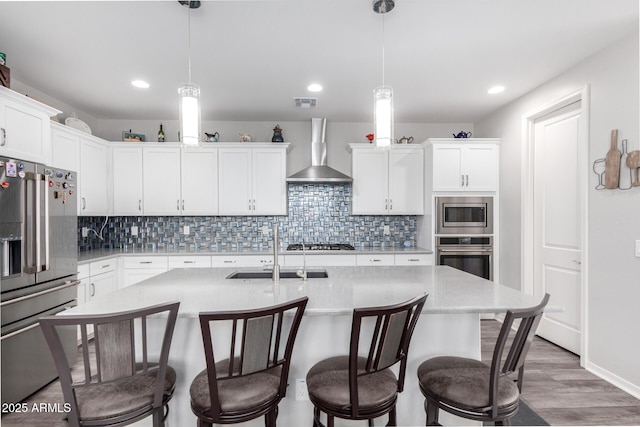 3585 W Oil Well Rd, San Tan Valley, AZ 85144 - kitchen with light countertops, wall chimney exhaust hood, appliances with stainless steel finishes, a sink, and a breakfast bar area