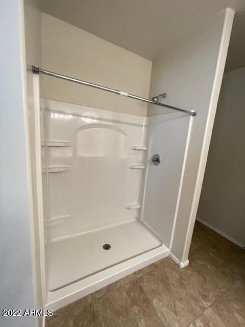 bathroom with tile flooring and walk in shower