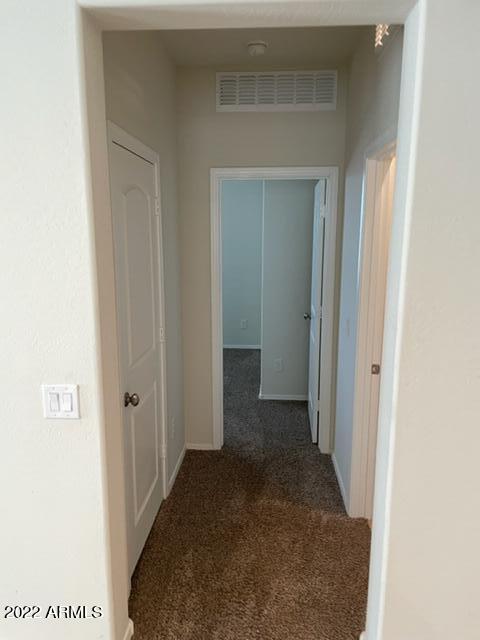 corridor with dark colored carpet