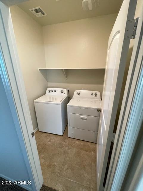 washroom with light tile floors and washer and dryer