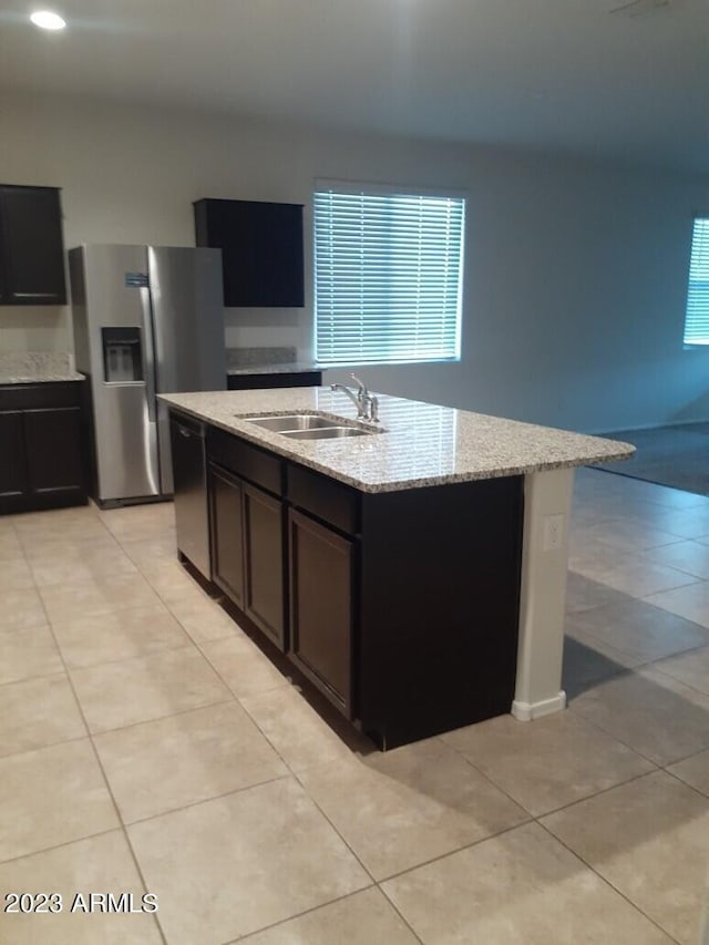 kitchen with a center island with sink, light tile floors, and sink