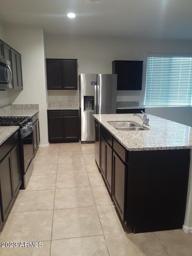 kitchen featuring light stone counters, light tile floors, appliances with stainless steel finishes, and sink