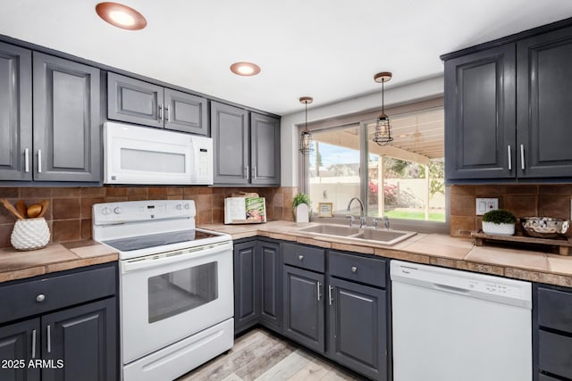 kitchen featuring gray cabinetry, sink, white appliances, and tile countertops