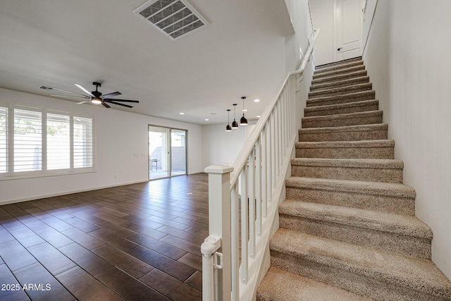 stairway with hardwood / wood-style flooring and ceiling fan