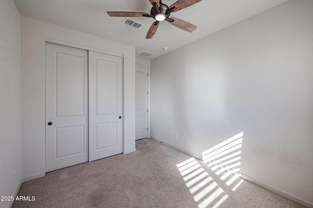 unfurnished bedroom featuring ceiling fan, a closet, and light carpet