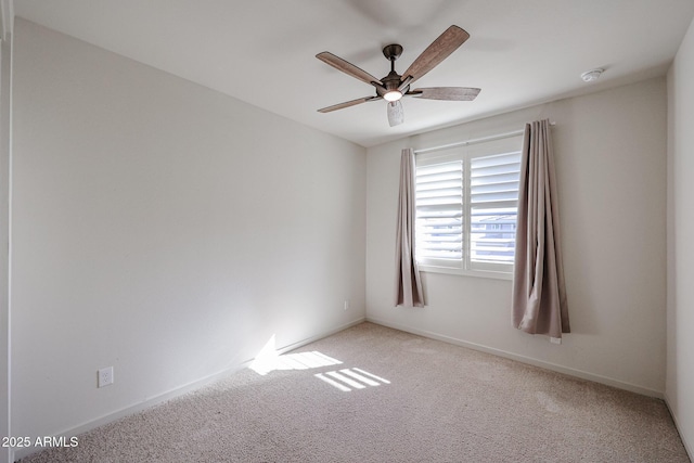 carpeted spare room featuring ceiling fan