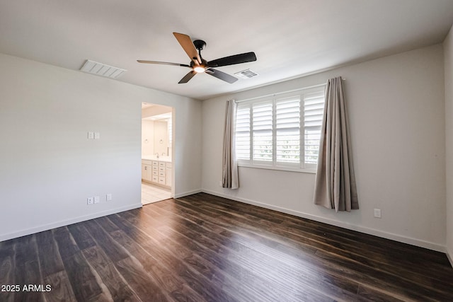 spare room featuring dark wood-type flooring and ceiling fan