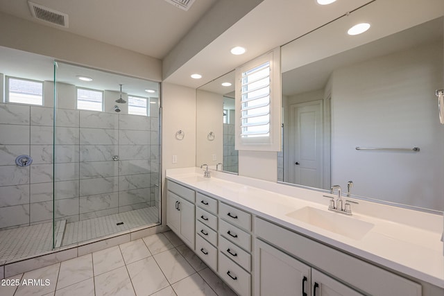 bathroom with a tile shower and vanity