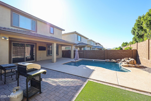 view of swimming pool featuring pool water feature, grilling area, and a patio