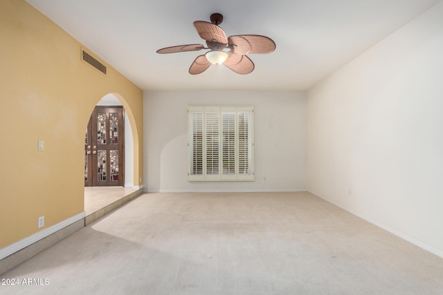 carpeted spare room featuring ceiling fan and french doors