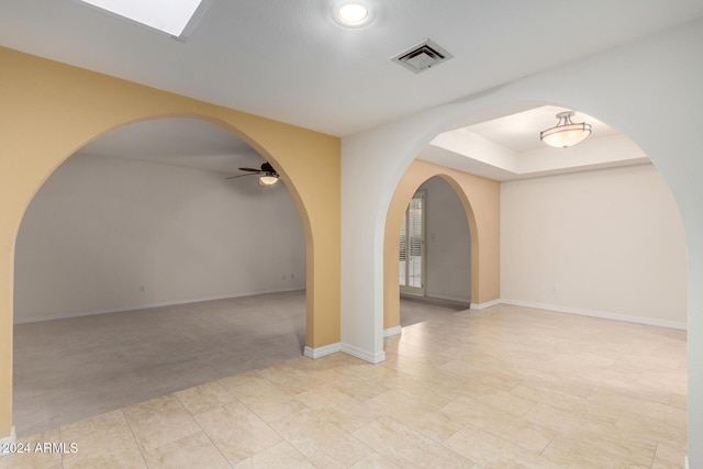 carpeted spare room with ceiling fan and a raised ceiling