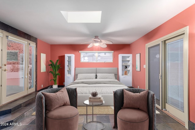 bedroom featuring access to exterior, a skylight, and ceiling fan