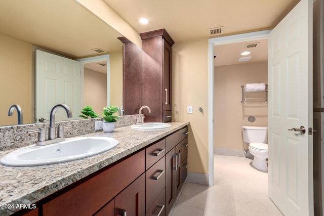 bathroom with tile patterned flooring, vanity, and toilet