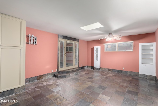 spare room with a skylight and ceiling fan