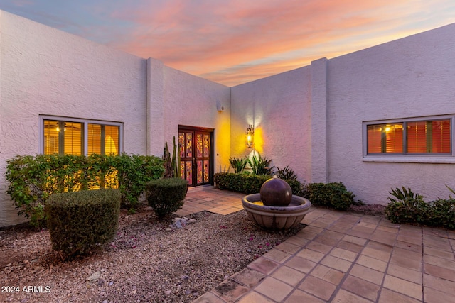 exterior entry at dusk featuring a patio